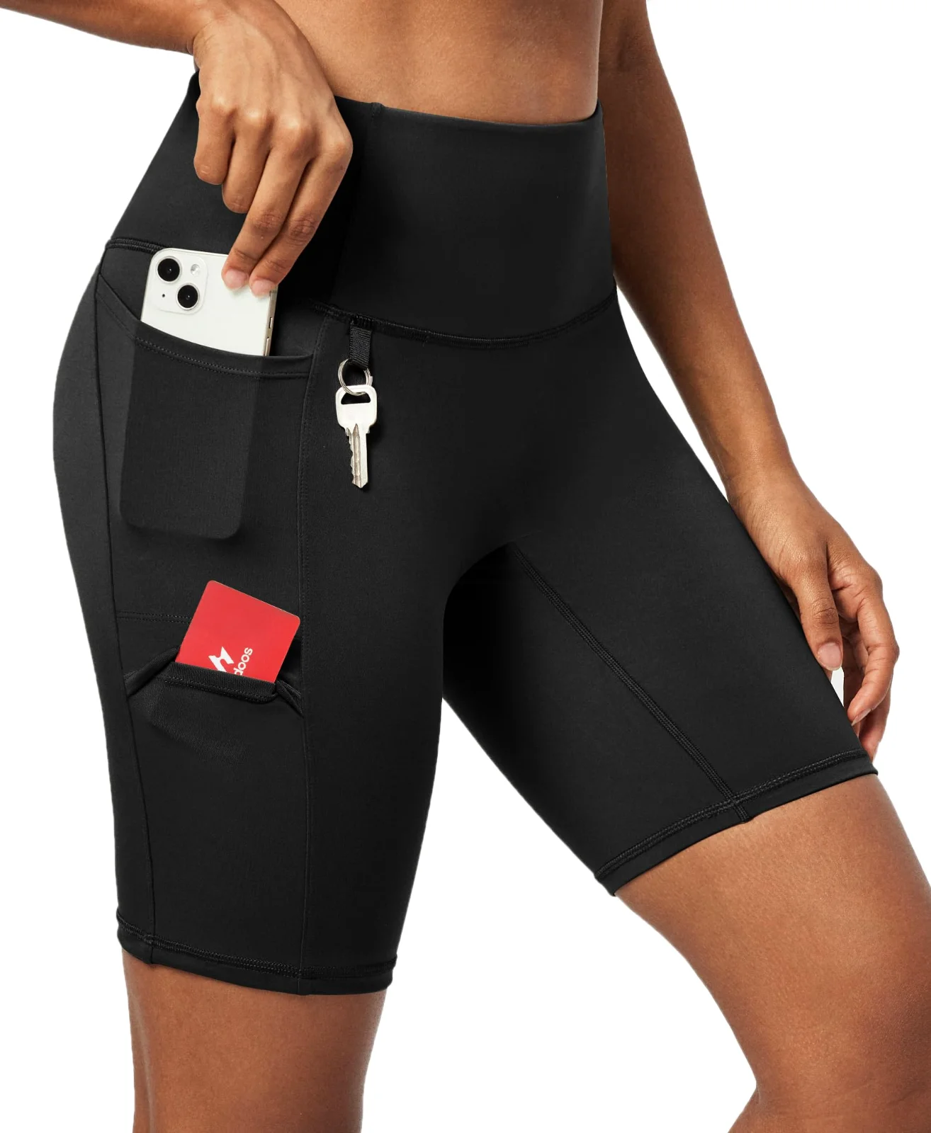 A phone and a key going into the side pocket of the Ewedoos four-pocket biker shorts, close up